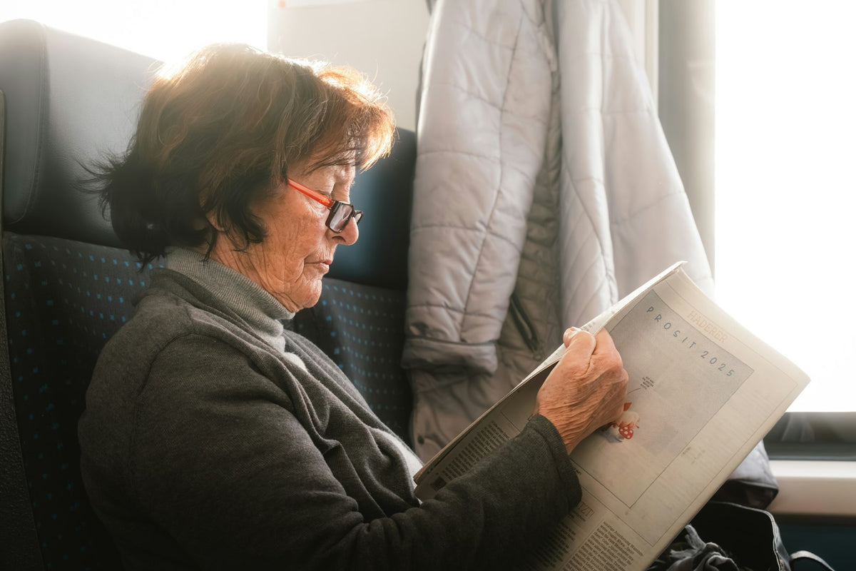 Older woman reading in her seat on a long journey